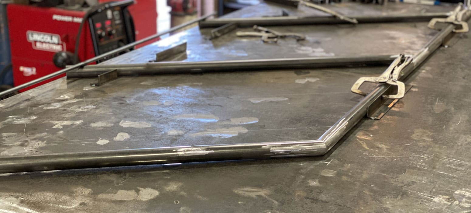 metal plate with bar and brakets in place for welding
